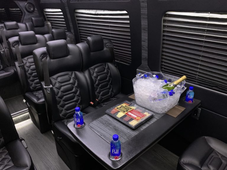 Inside a Mercedes Sprinter: leather seats, table and bottled water