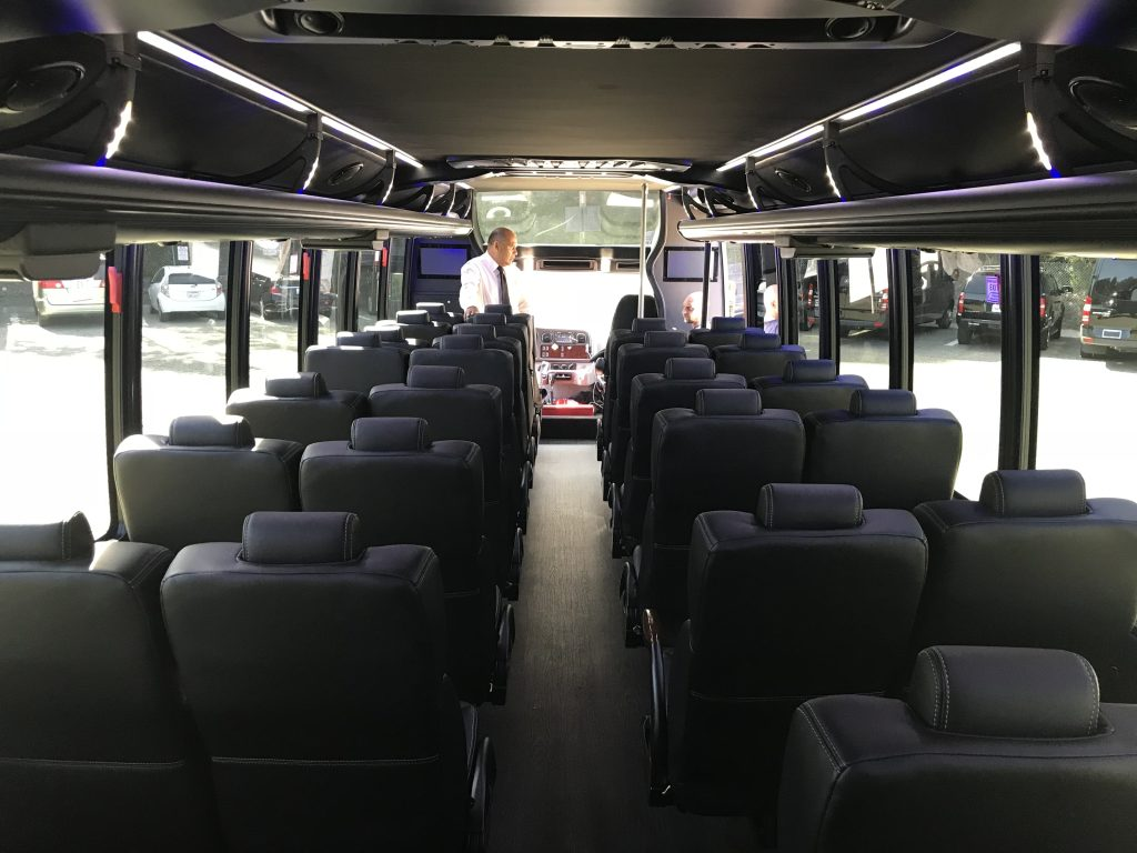 A mini coach with man standing in it