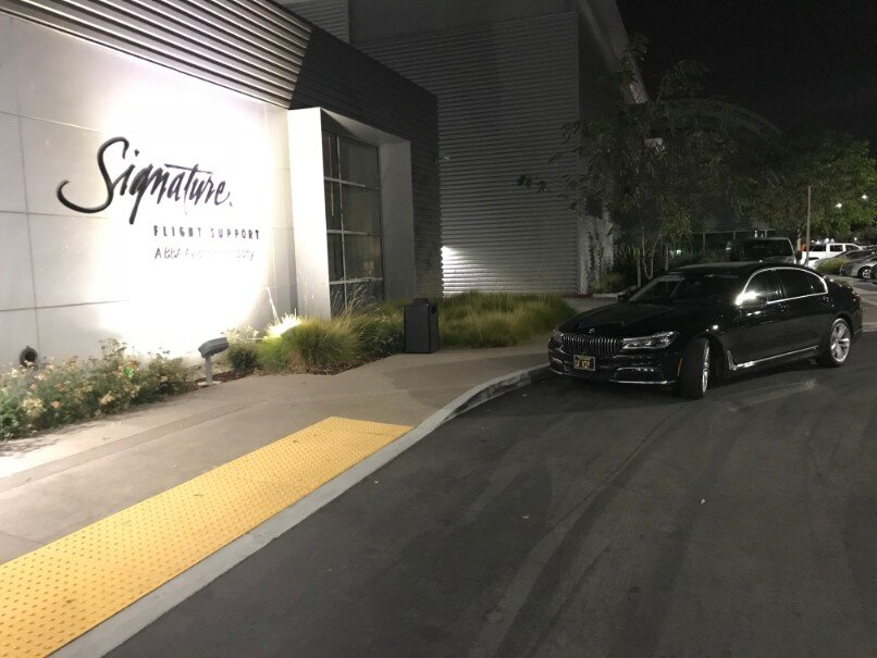 A black BMW car waiting outside a building