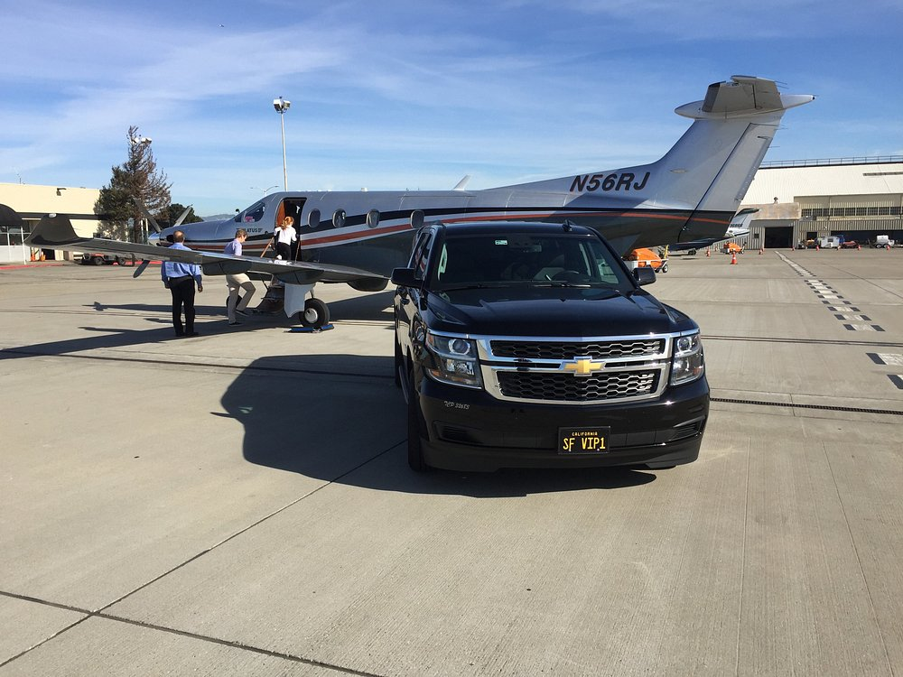 Limo SF VIP’s Black Chevrolet Suburban parked on an airport tarmac beside a private turboprop aircraft.