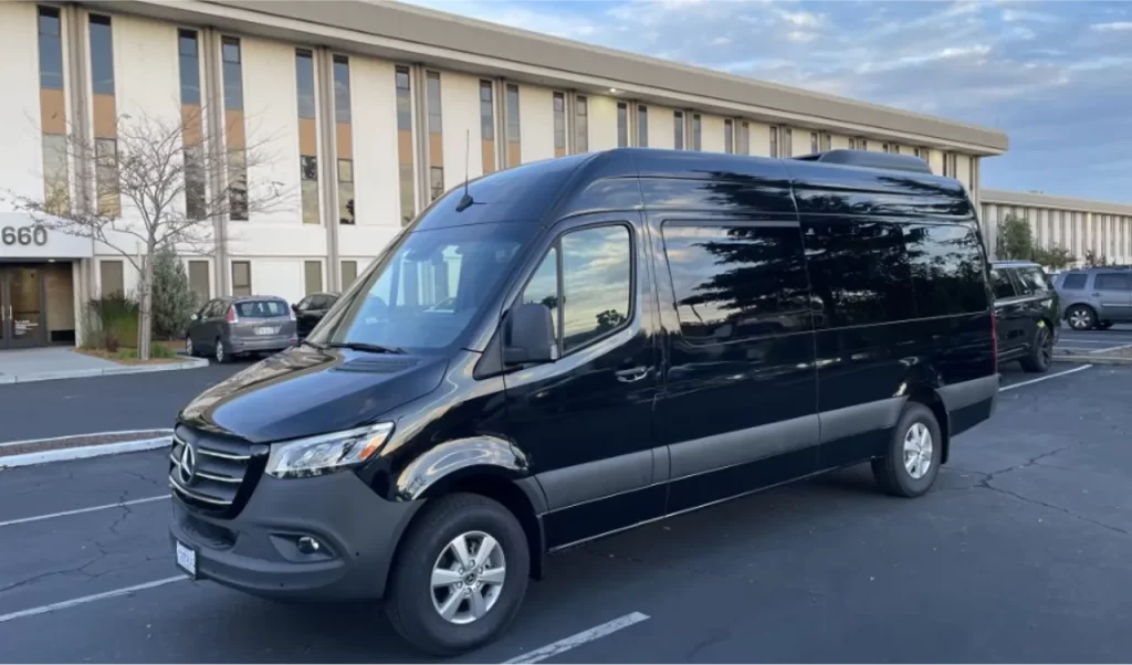 Black Mercedes Sprinter van parked outside an office building