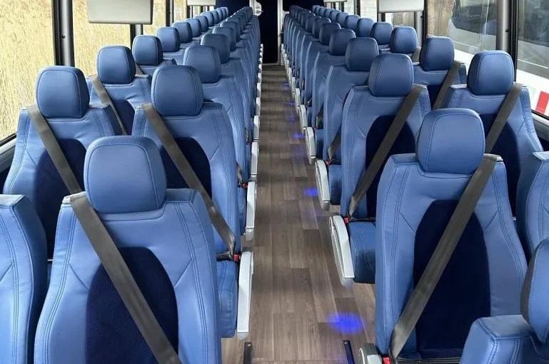 Volvo 9700 coach interior with blue reclining seats and seat belts