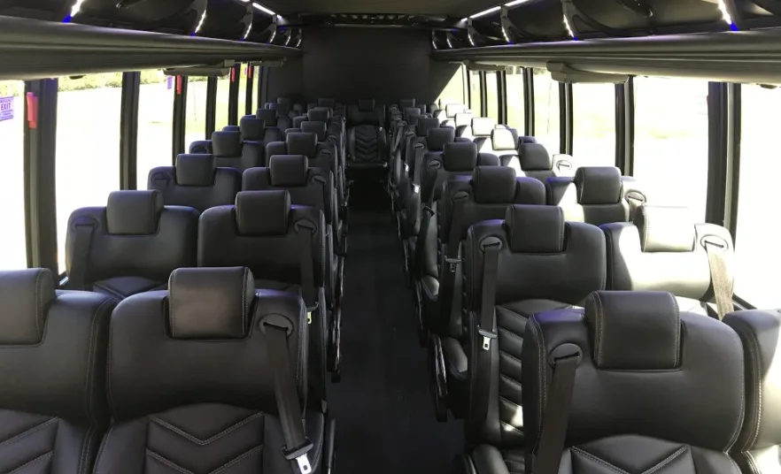 Mini coach interior with rows of black leather reclining seats
