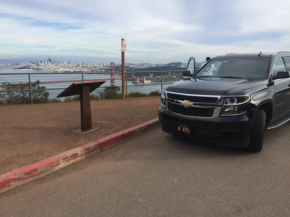 Black Chevrolet Suburban at an overlook facing the San Francisco skyline