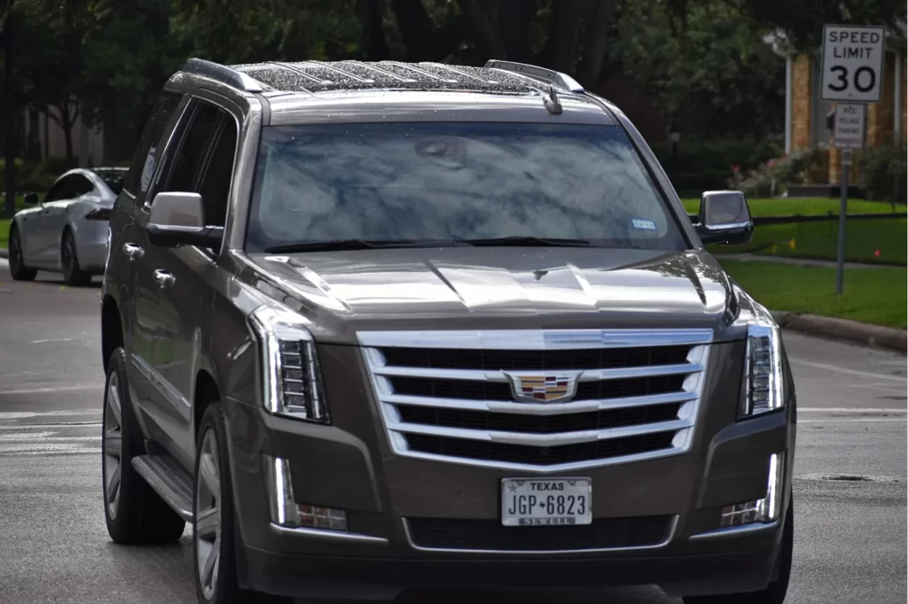Dark Cadillac Escalade parked on a residential street