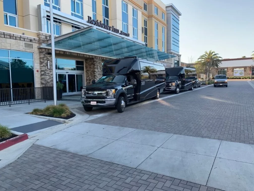 Two black shuttle buses parked at a hotel entrance