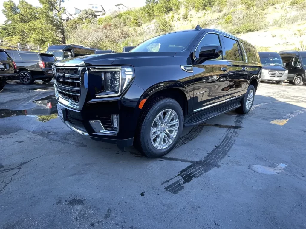 Black GMC Yukon SUV parked in a lot with other SUVs