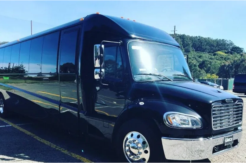 Black mini coach bus parked in a lot