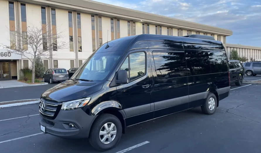 Black Mercedes Sprinter van parked outside an office building