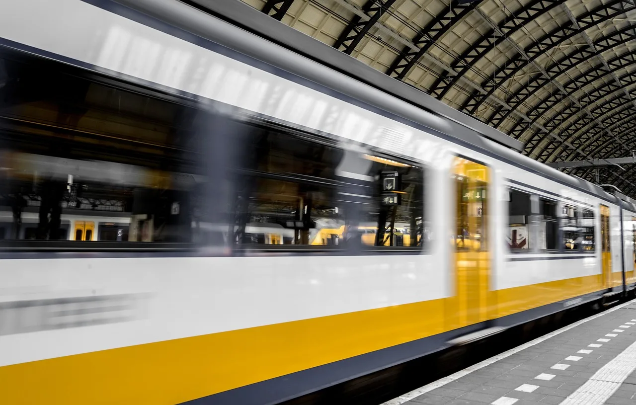 Commuter train speeding through a covered rail station