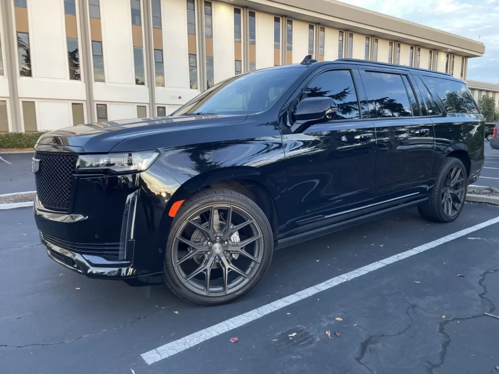 Black Cadillac Escalade ESV parked outside an office building