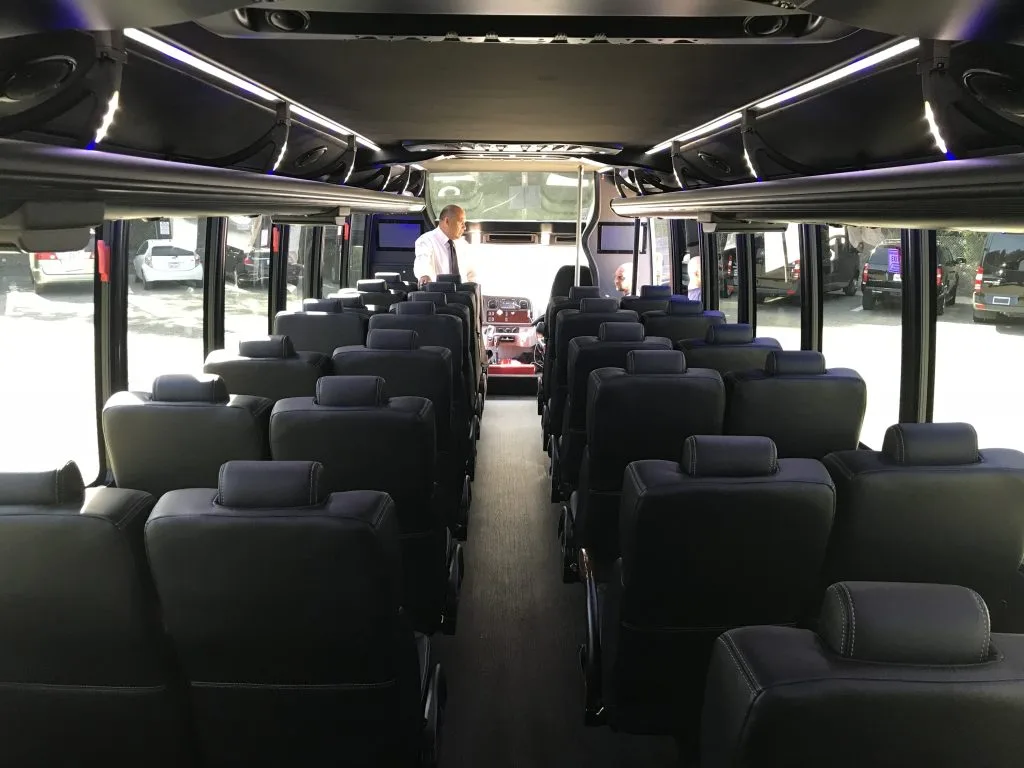 A mini coach with man standing in it