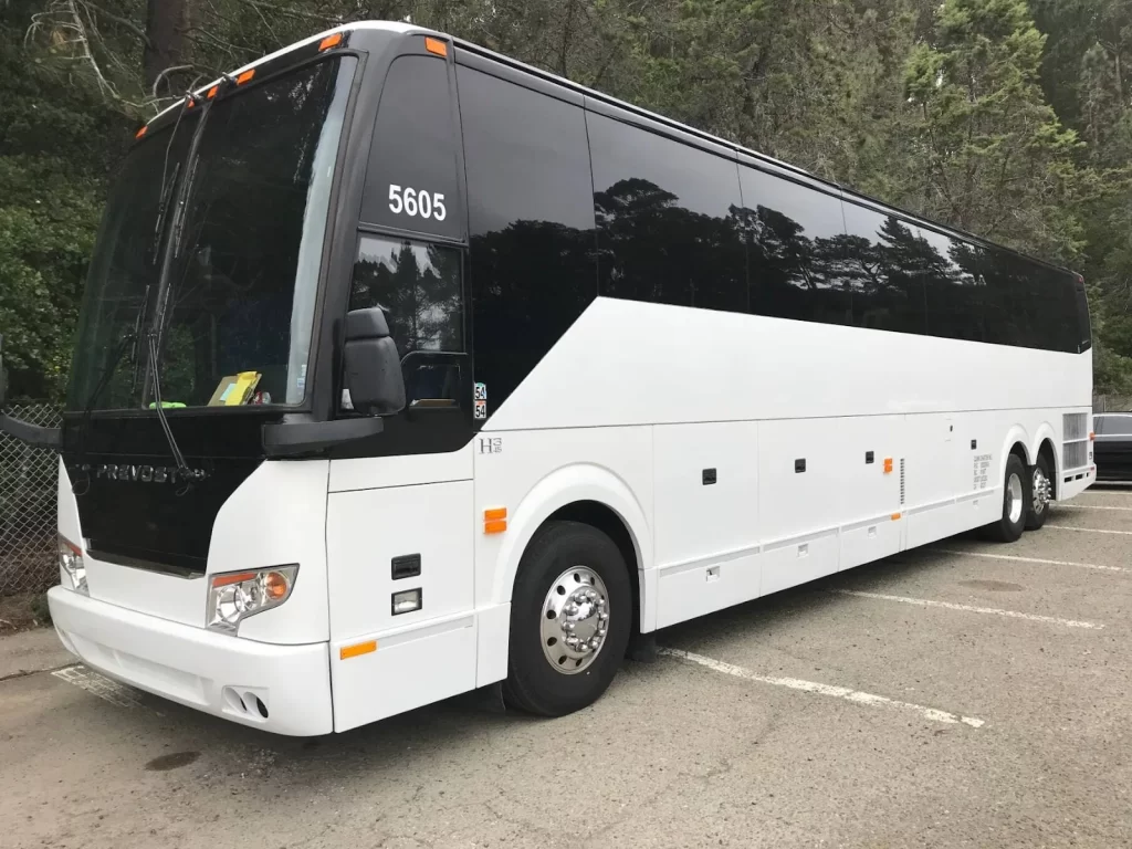 White motorcoach bus parked in a lot, used for employee shuttle service