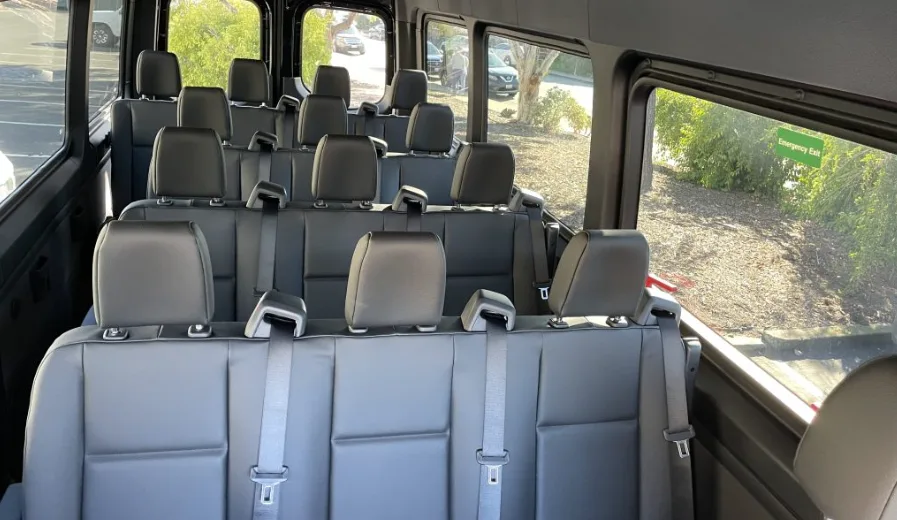 Rows of gray passenger seats inside a Mercedes Sprinter van