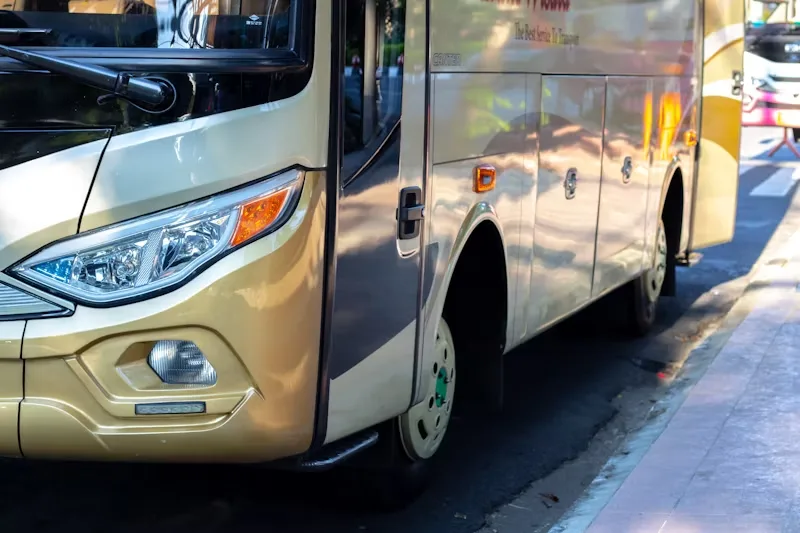 Close-up of a gold motorcoach bus headlight and front door