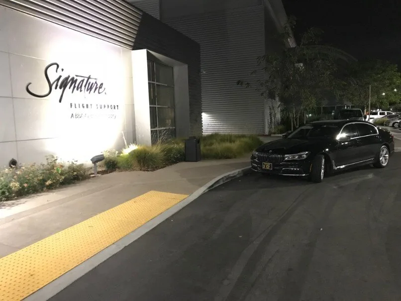A black BMW car waiting outside a building